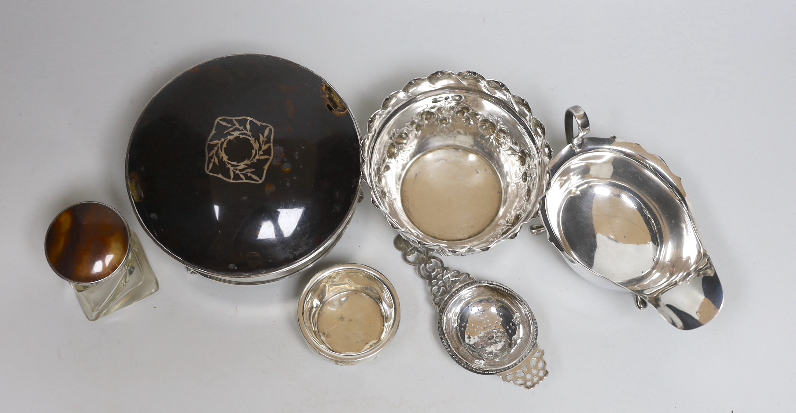 Small silver to include a late Victorian sugar bowl, London, 1898, a tea strainer on stand, a sauceboat, a trinket box (a.f.) and a mounted glass perfume bottle.